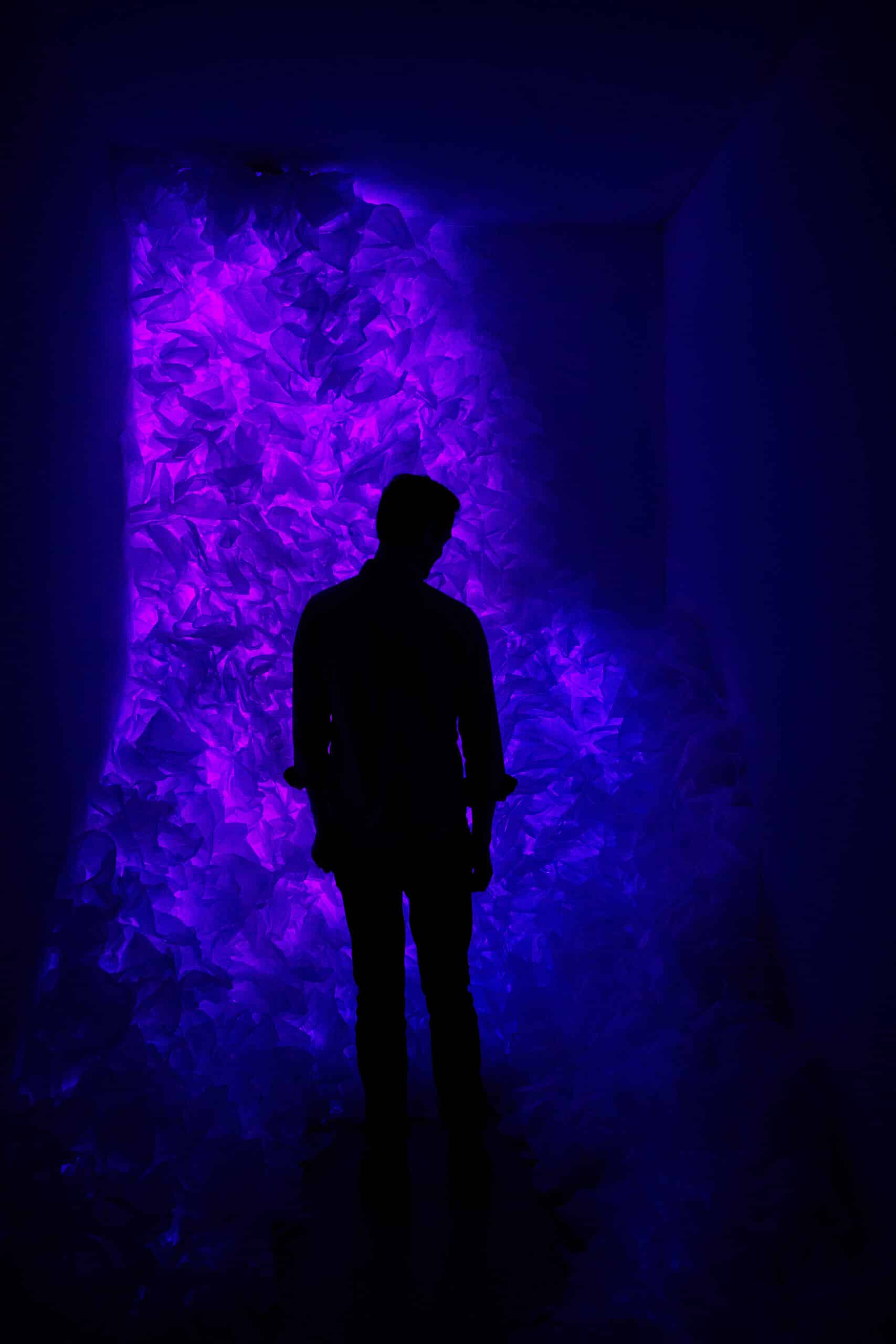 installation d'une galerie de lumière violette avec une personne en silhouette