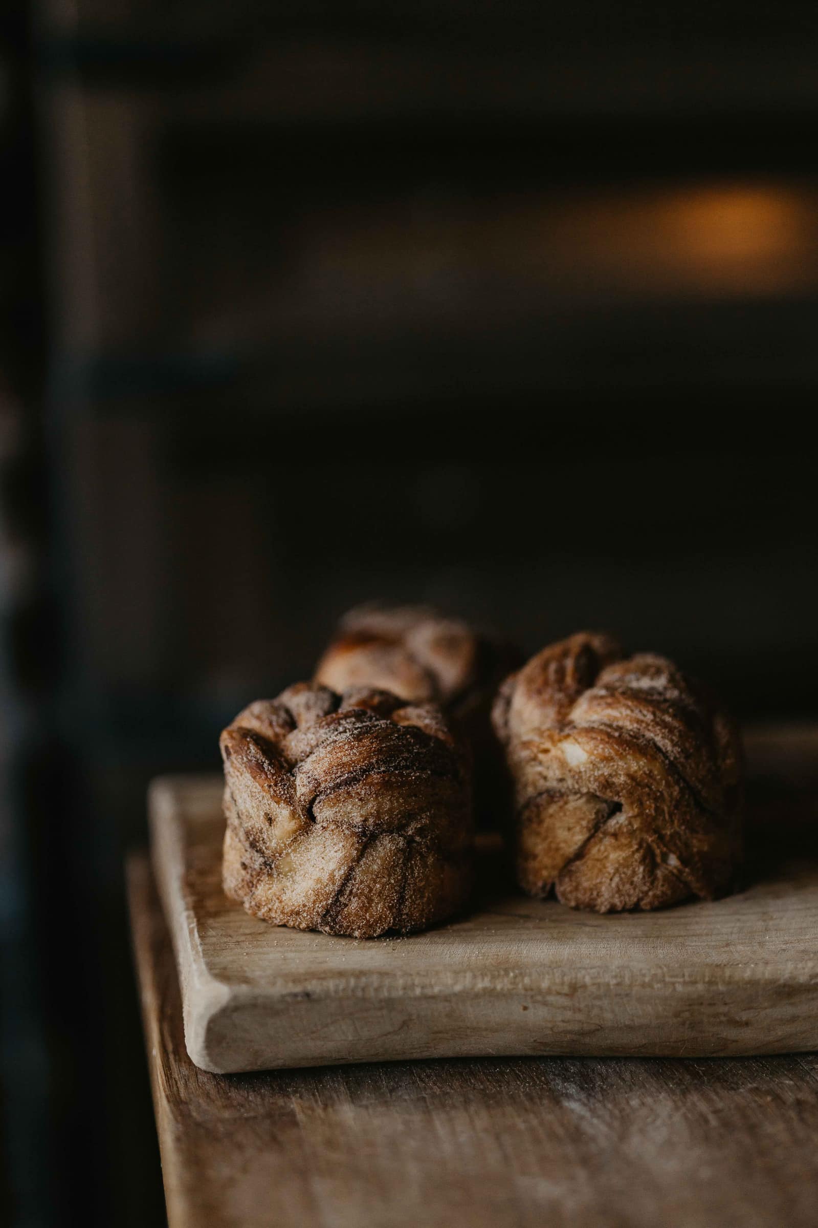 photo of braided buns on a wooden cutting board by Ashleigh Britten