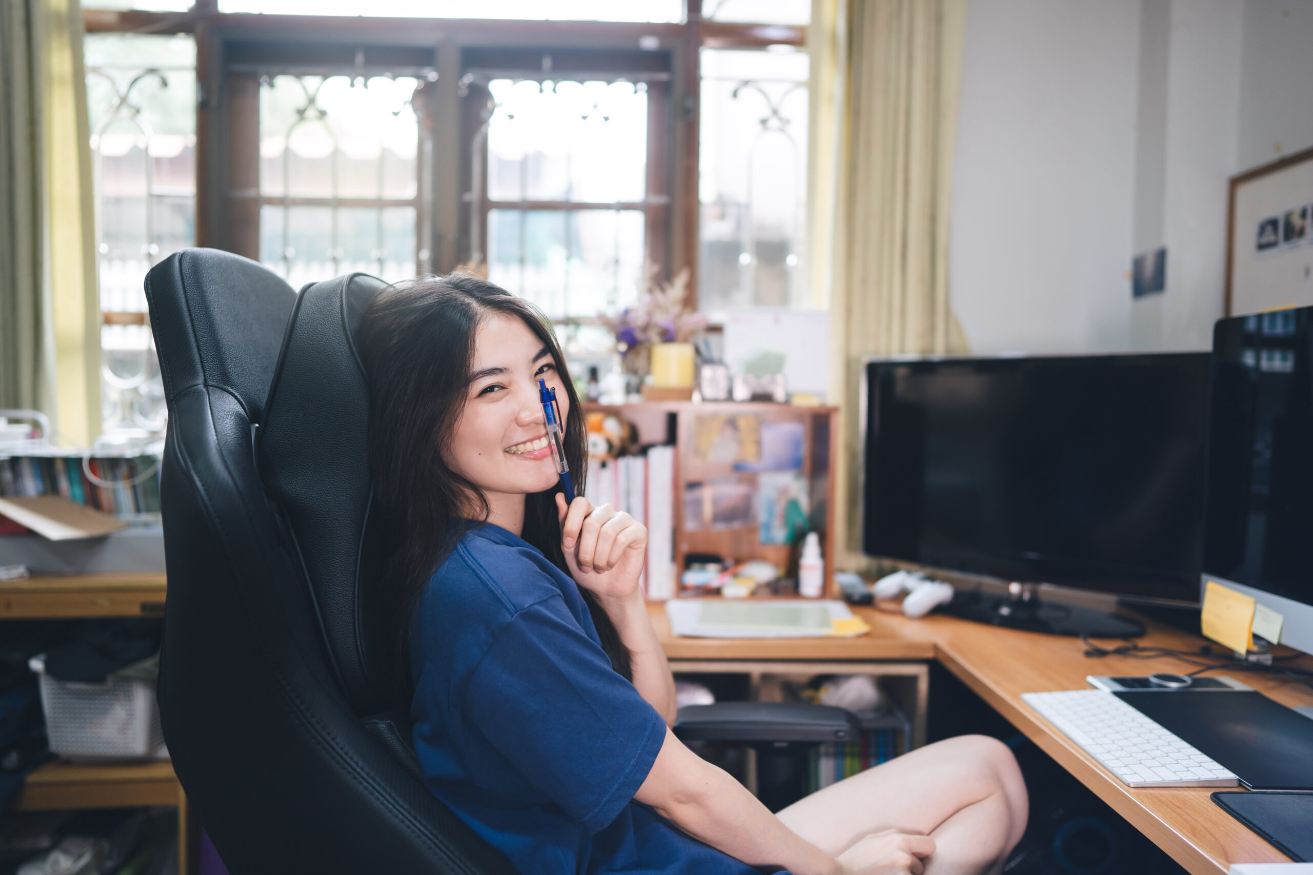 Portrait of smiling female adult freelancer in workplace with computer at home.