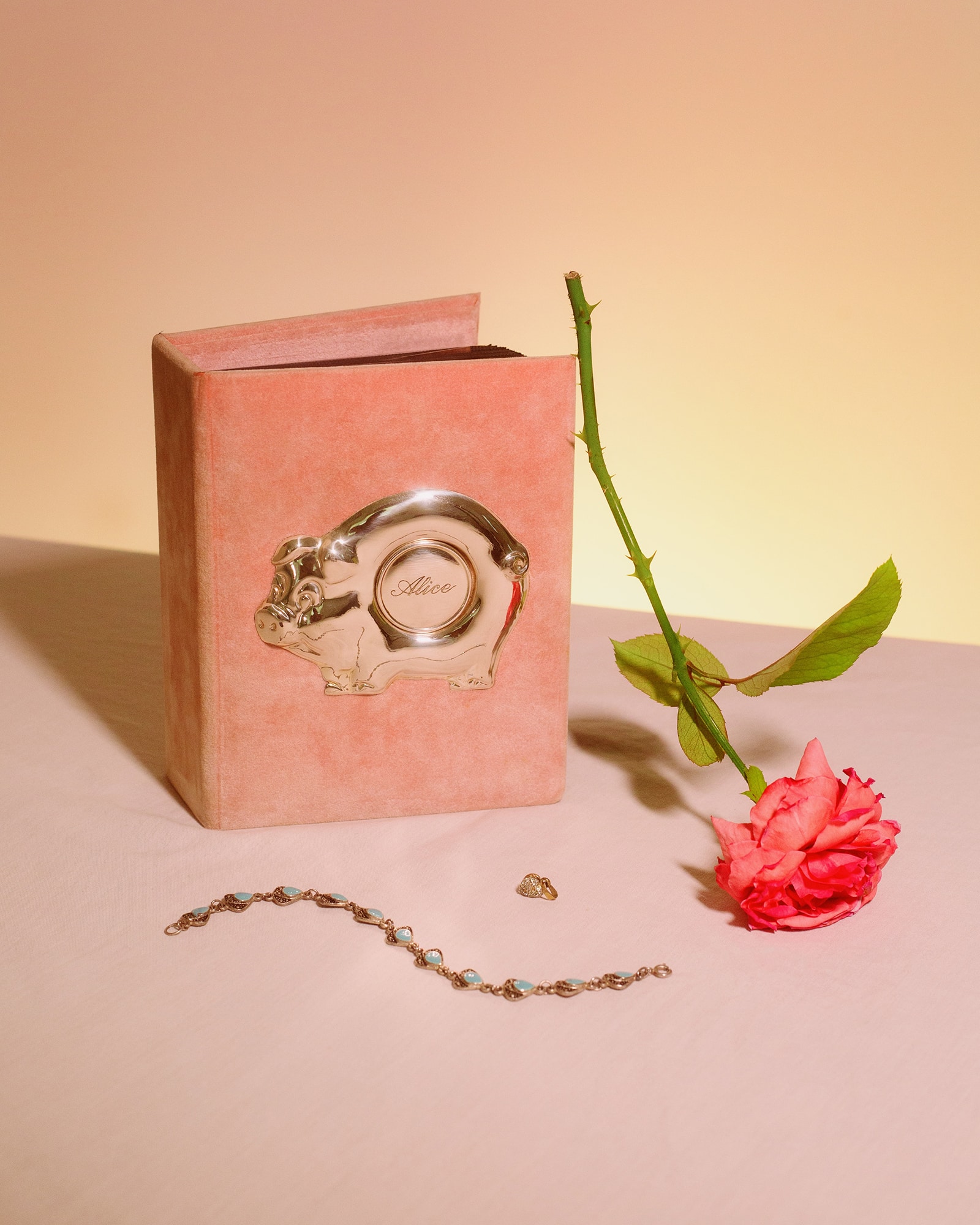 photograph of pink album labelled "Alice" beside a bright pink rose and jewelry