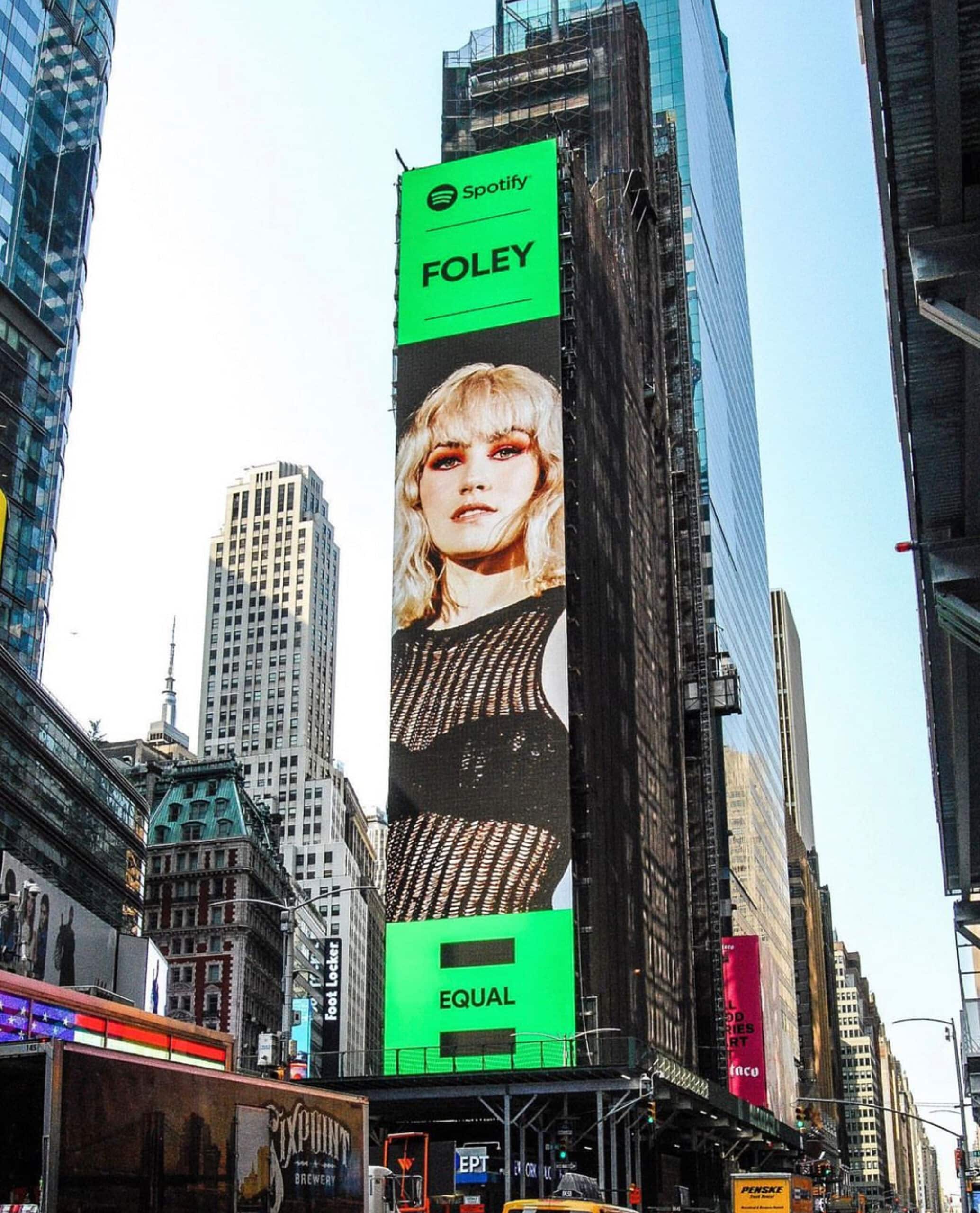 Frances Carter portrait of musician in spotify ad on a large screen on the side of a building