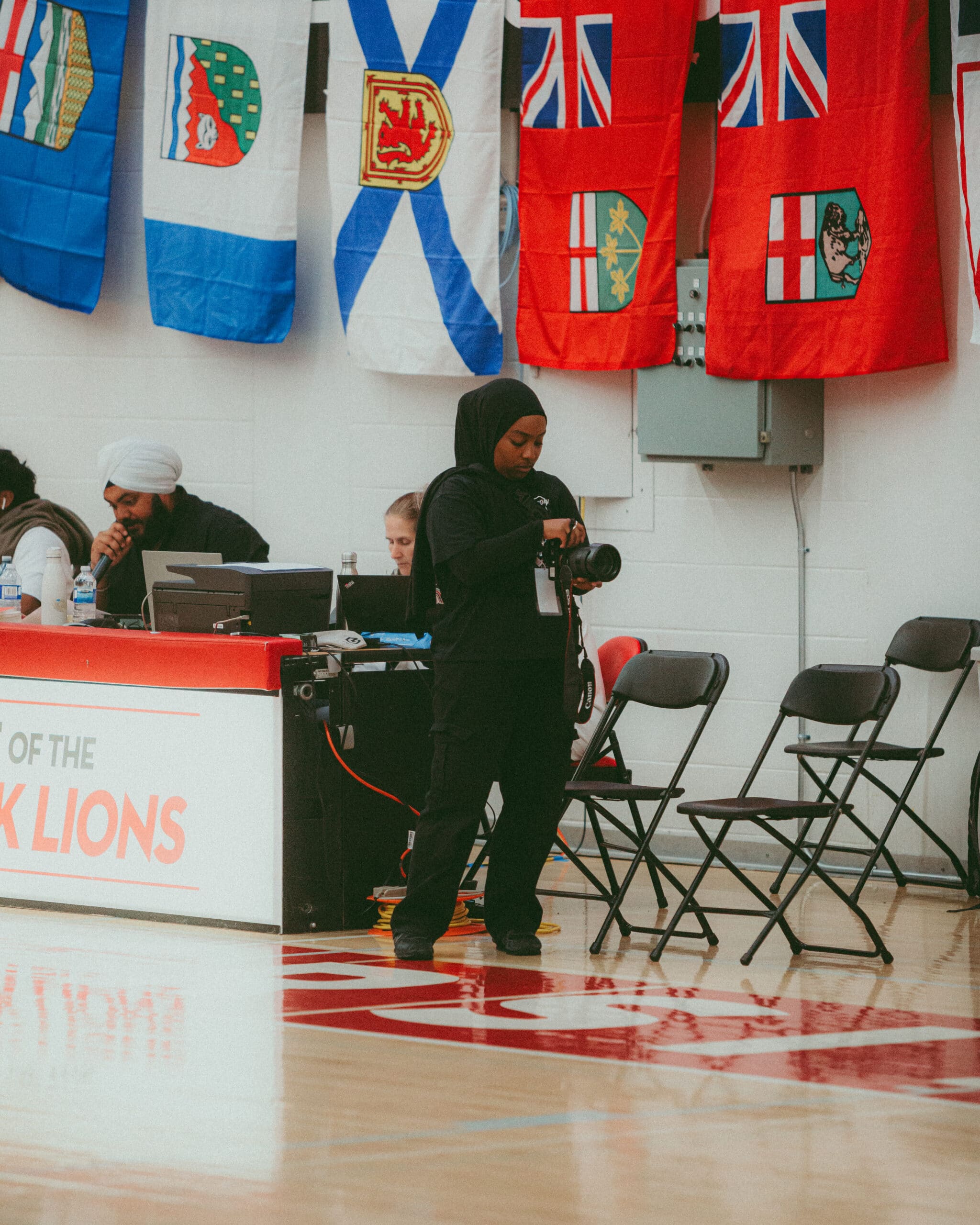 Portrait d'Aliya Ahmed, membre du portefeuille Kickback, regardant son appareil photo pendant les championnats nationaux de basket-ball du Canada.