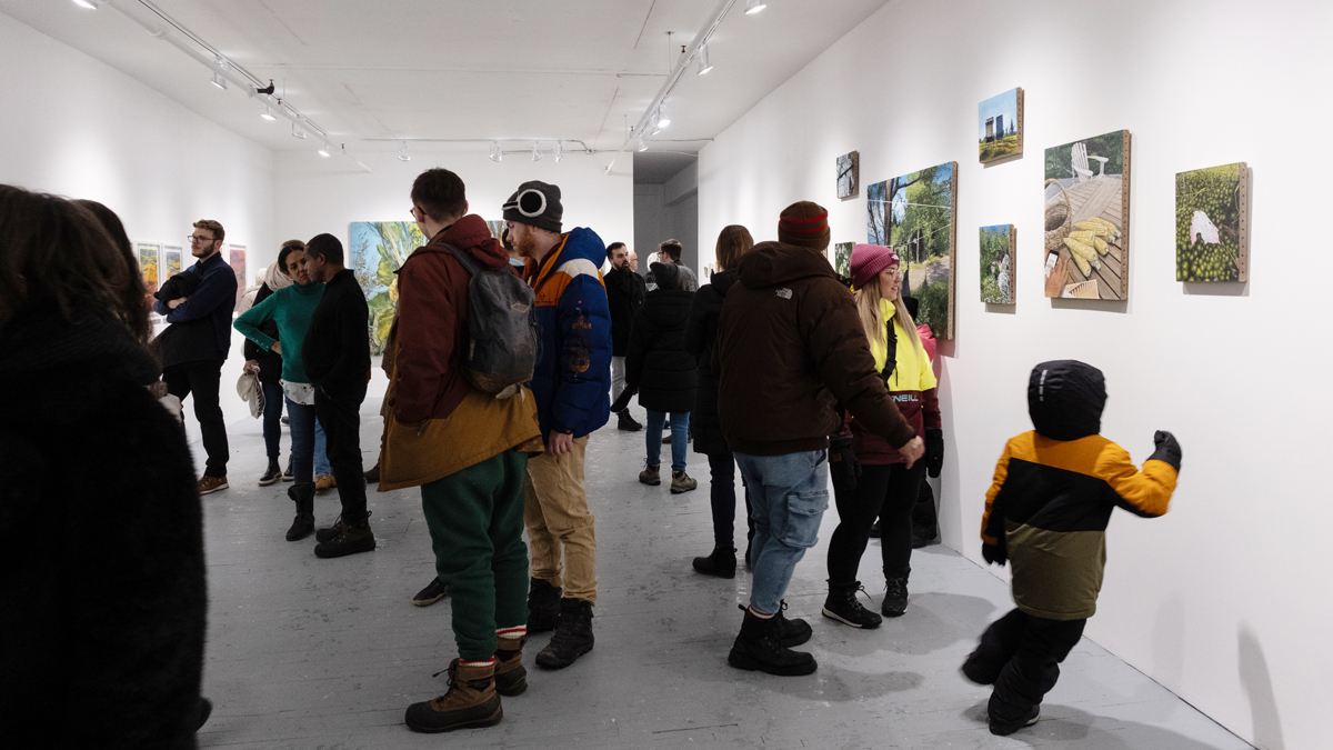 Nuit Blanche Montreal na cache gallerie, cheia de pessoas e com arte nas paredes de Emile Brunet e Jasmine Bilodeau