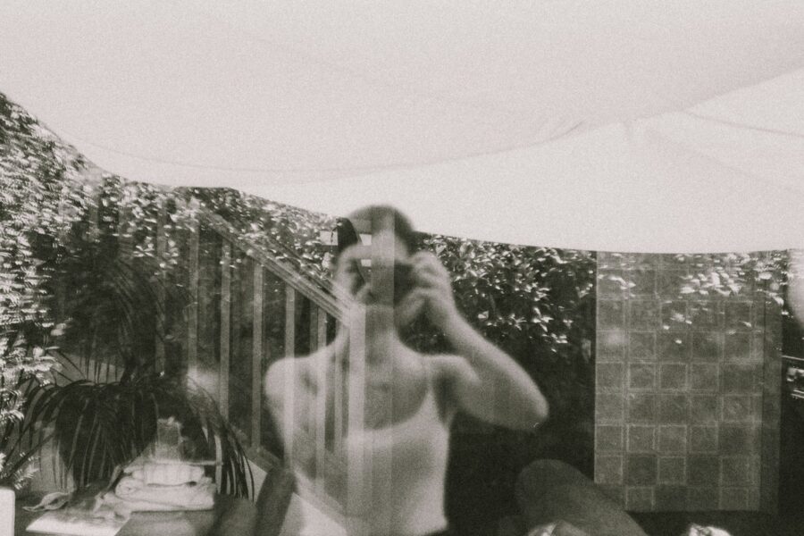 Autorretrato em preto e branco do reflexo do fotógrafo em uma janela