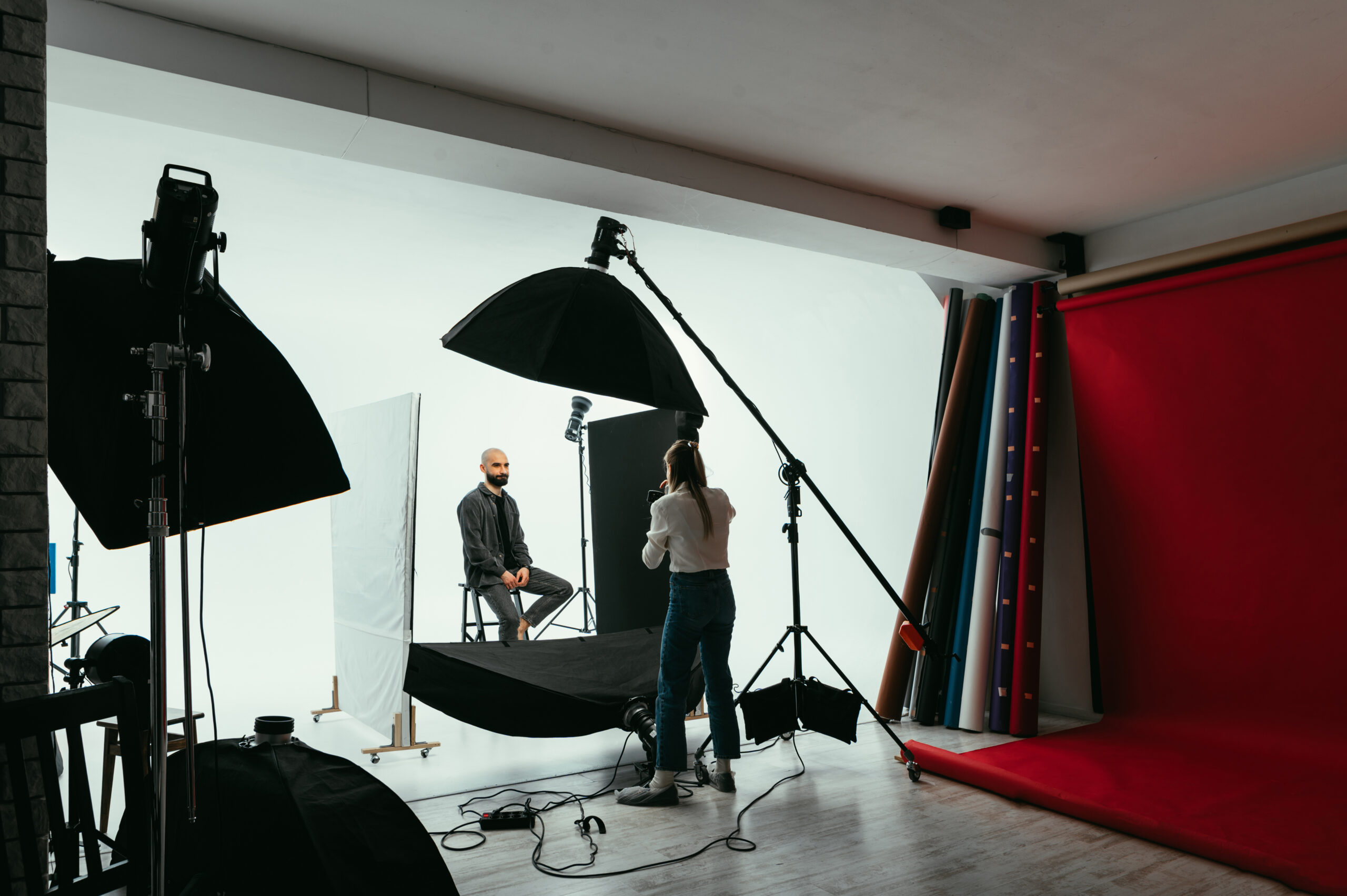 Photographe professionnel travaillant en studio avec un modèle masculin sur fond blanc