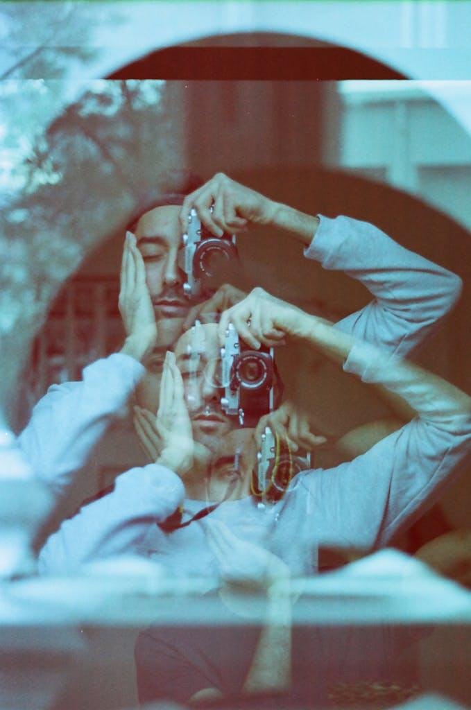 Foto de exposição múltipla de um homem tirando um autorretrato usando seu reflexo