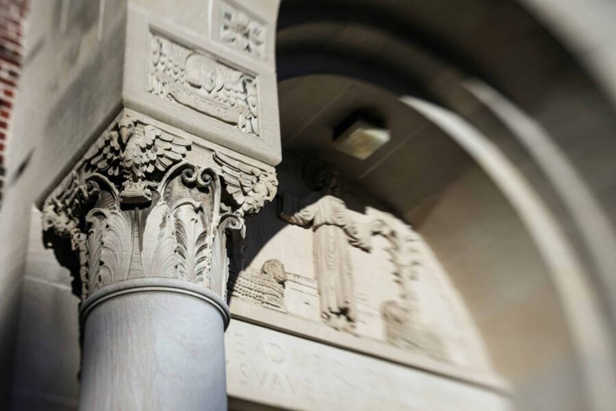 photo de basculement mettant l'accent sur les détails architecturaux d'un pilier en pierre sur un campus universitaire.