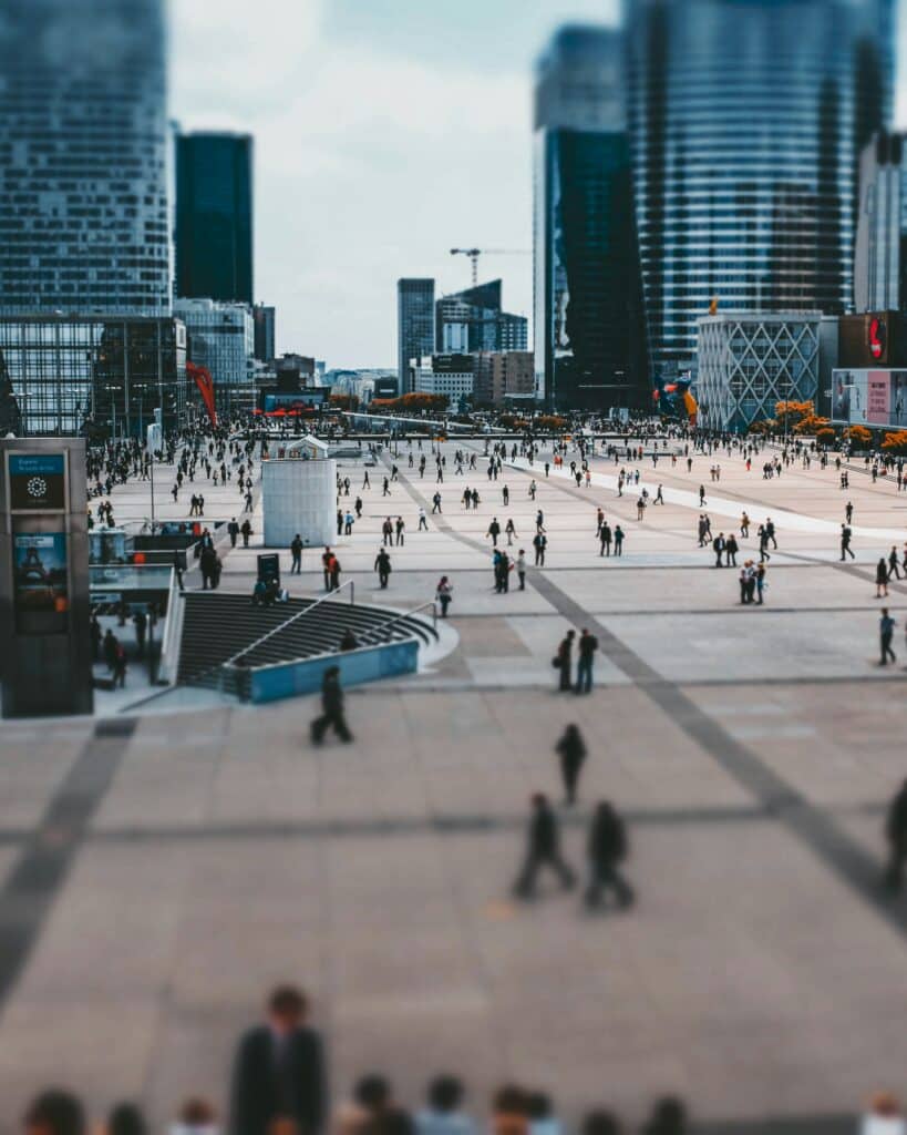 tilt shift photo of many people walking through a city square