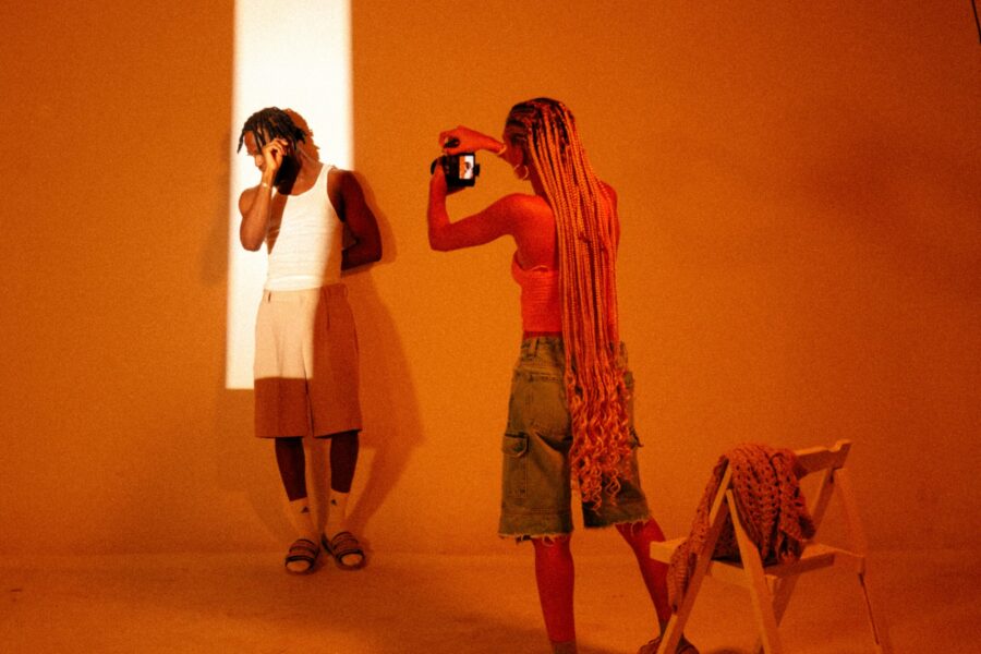 woman with long braids photographing man in vertical sliver of light scaled e1717696094897